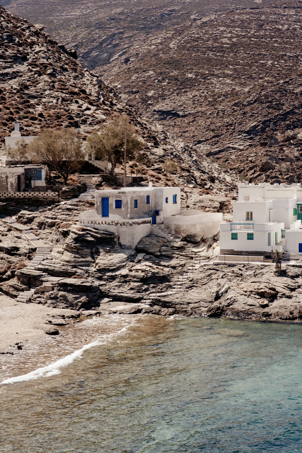 Whitewashed Cycladic hamlet above rocky coast