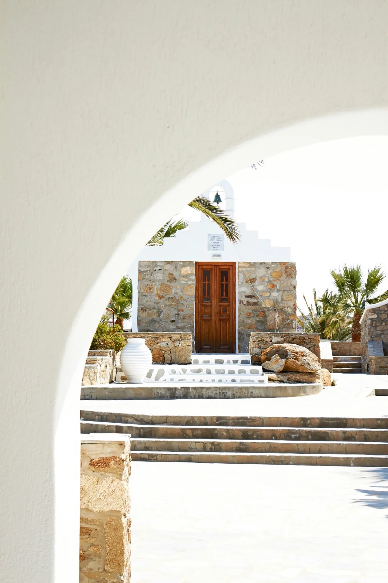 Stone chapel framed by Cycladic arch, Greece