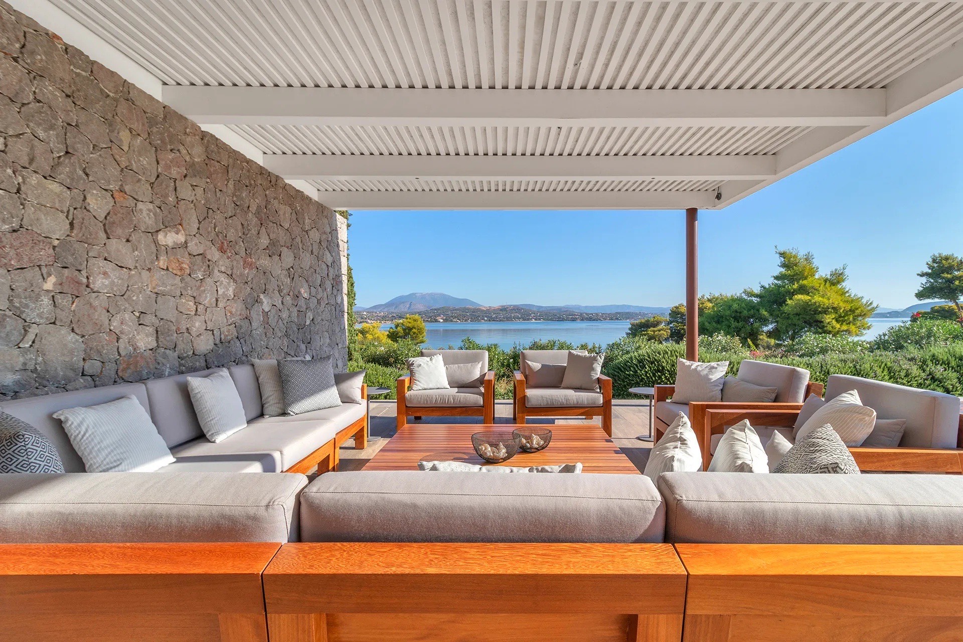 Outdoor dining for fourteen under a stone-walled pergola