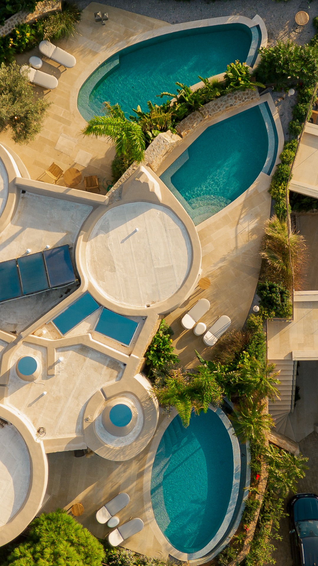 Aerial of the five sculpted outdoor pools at golden hour