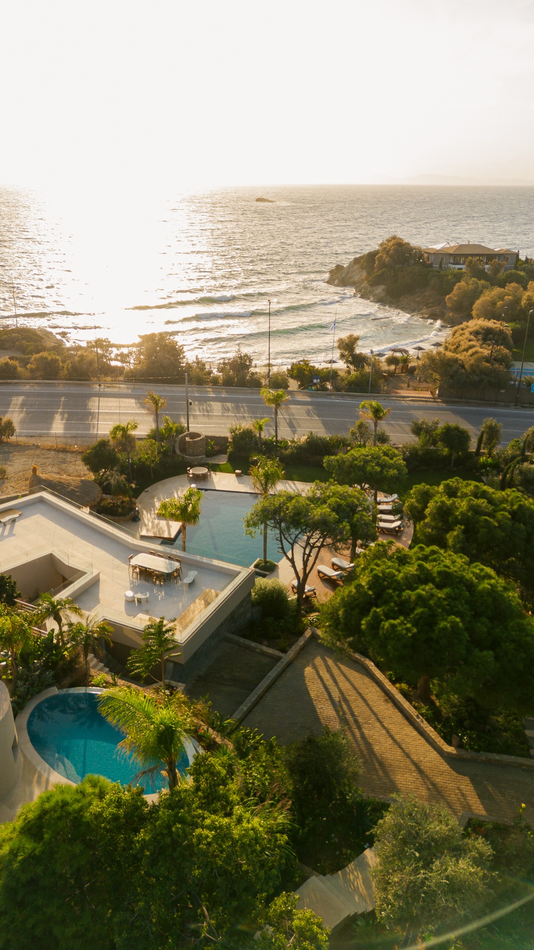 View from the estate to the sea at sunset, pools and gardens in foreground