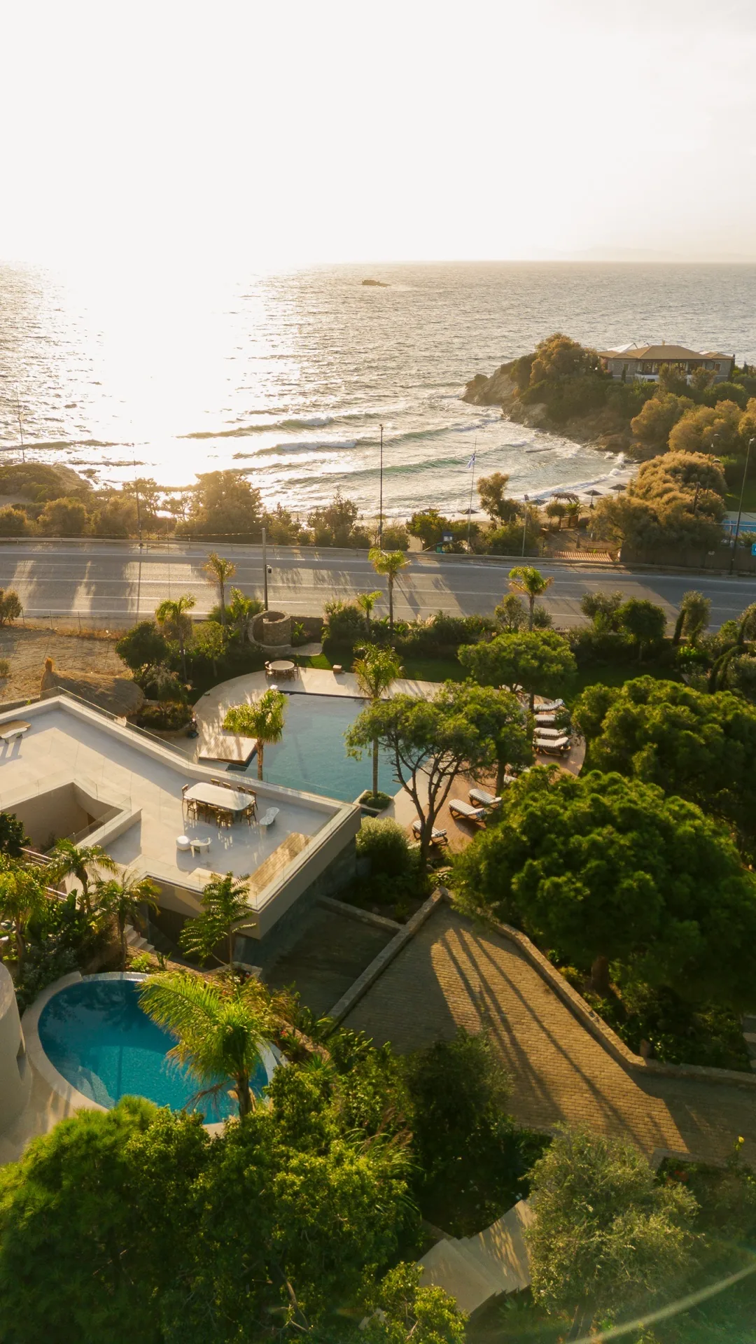 View from the estate to the sea at sunset, pools and gardens in foreground