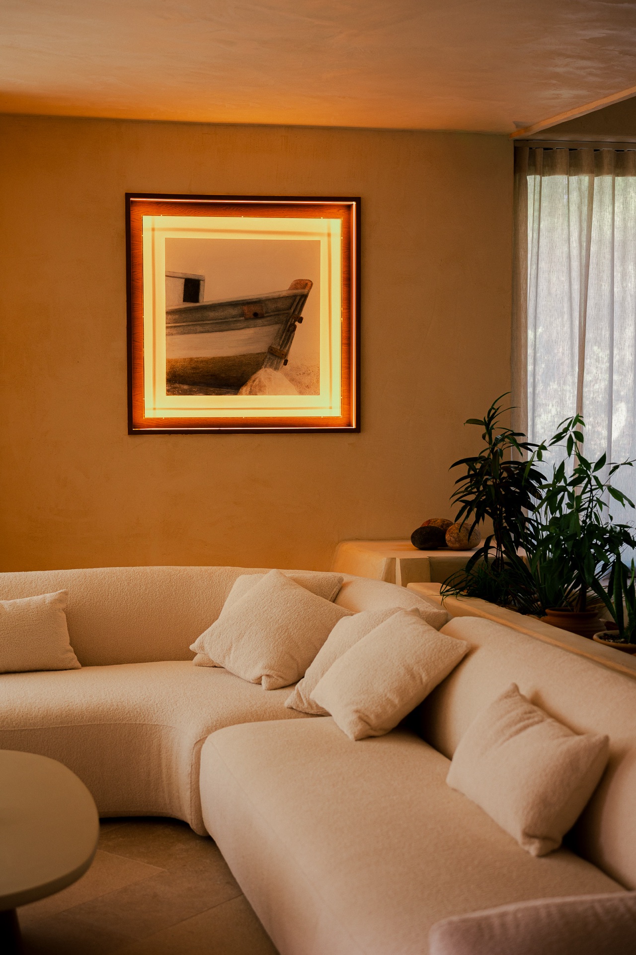 Living lounge in warm earthy tones, curved boucle sofa, framed artwork