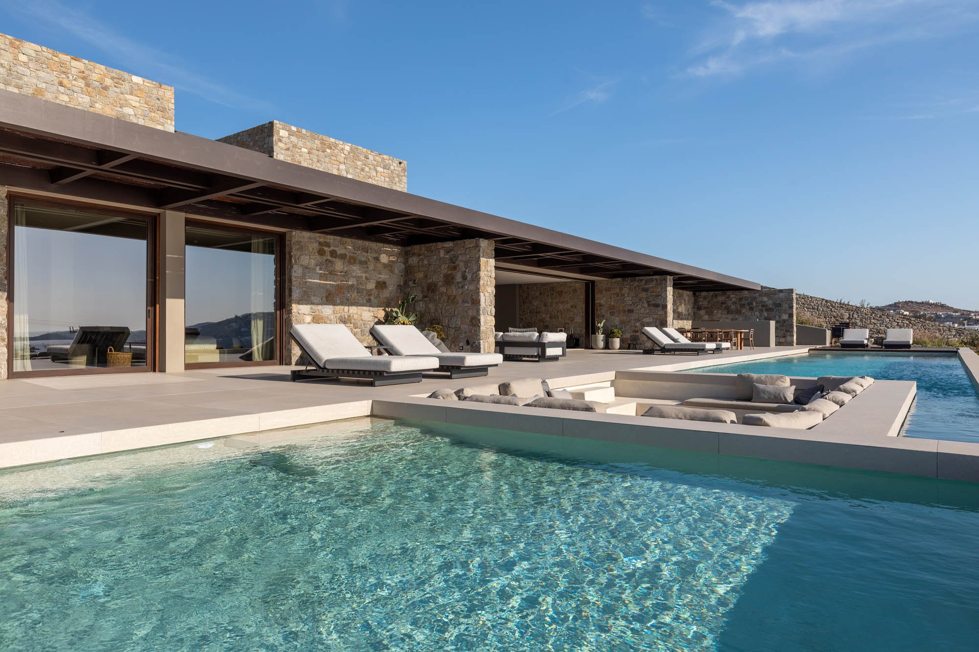 Pool and sunken lounge set against stone architecture
