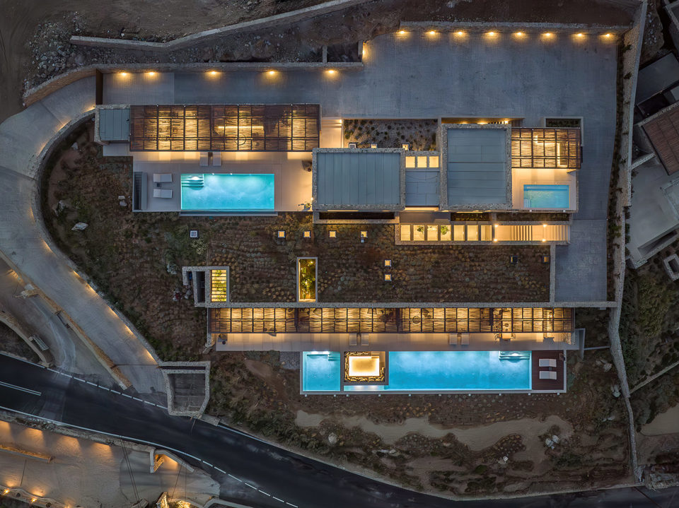 Aerial of Villa Celestia at dusk, twin pools illuminated across the levels