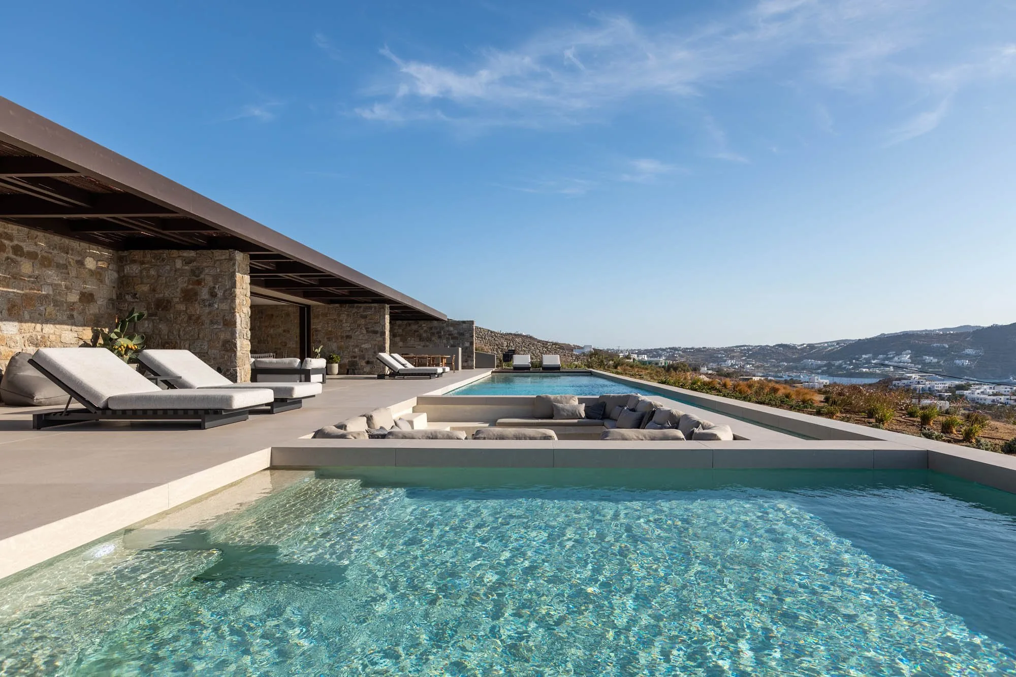 Twin pools with sun loungers and central sunken lounge
