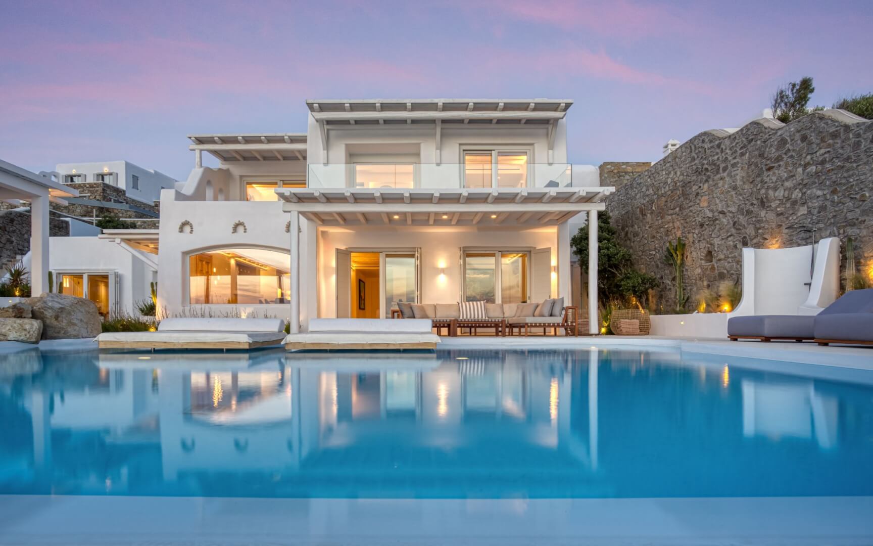 Main pool reflecting the villa at twilight