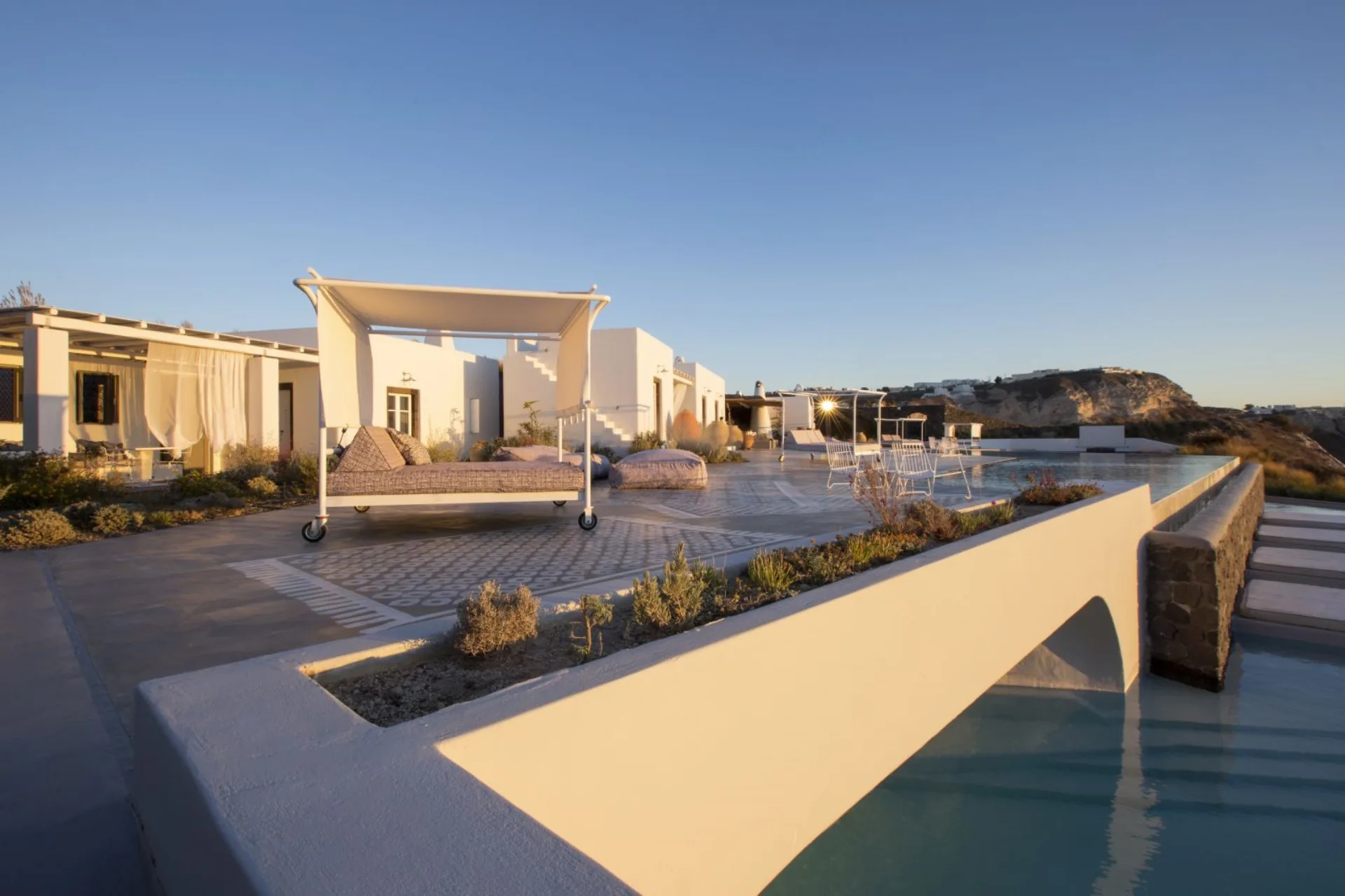 Daybed and infinity pool at golden hour