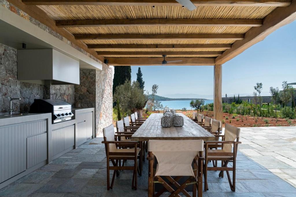 Outdoor dining for twelve under a bamboo pergola, Argolic Gulf beyond