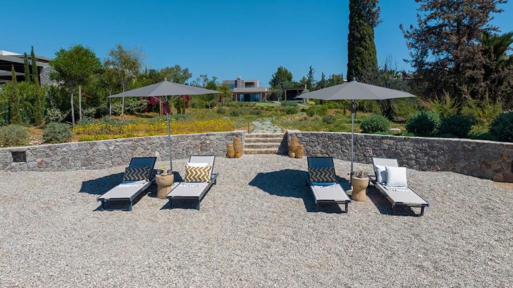 Garden lounge with parasols and sun loungers above the stone retaining wall