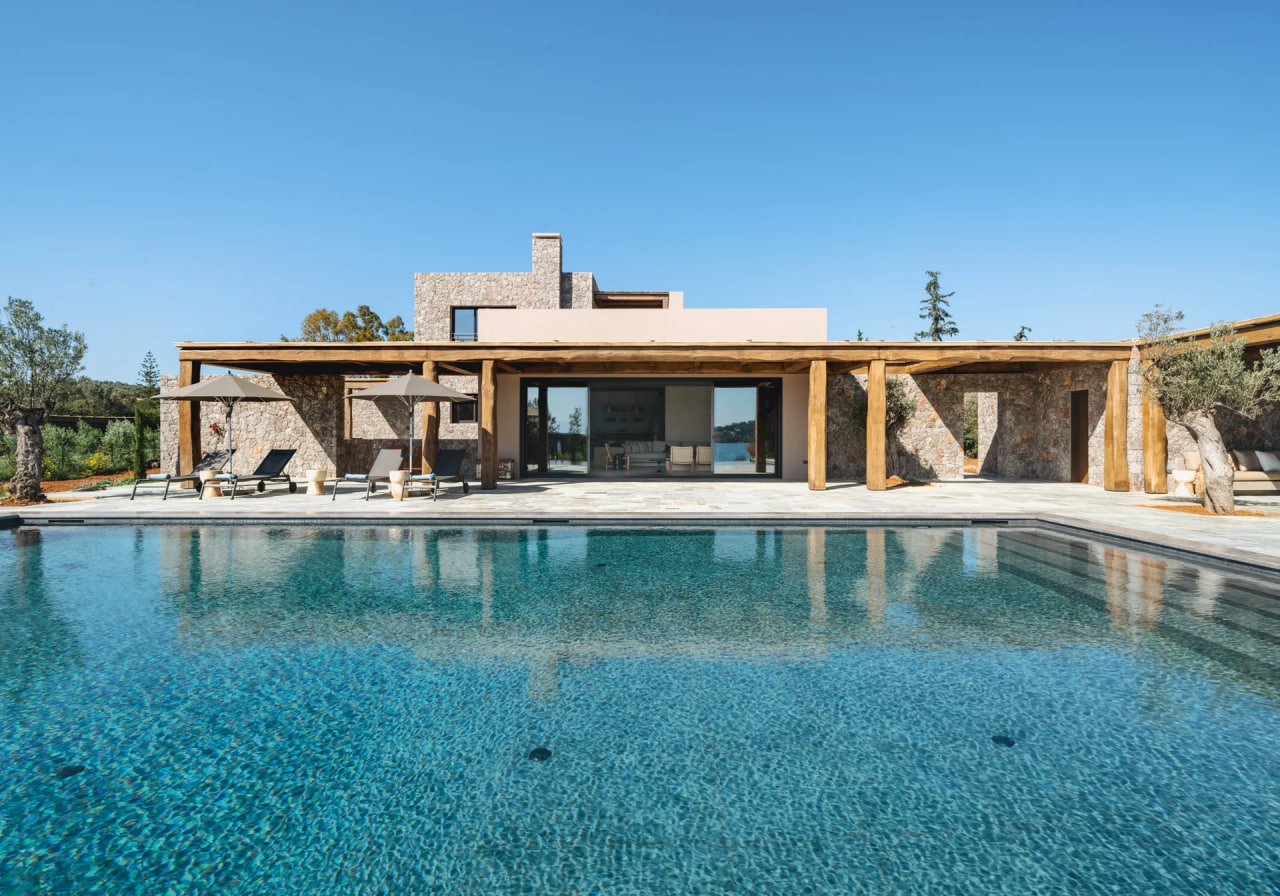 Pool side of the residence, stone columns and open glass facade