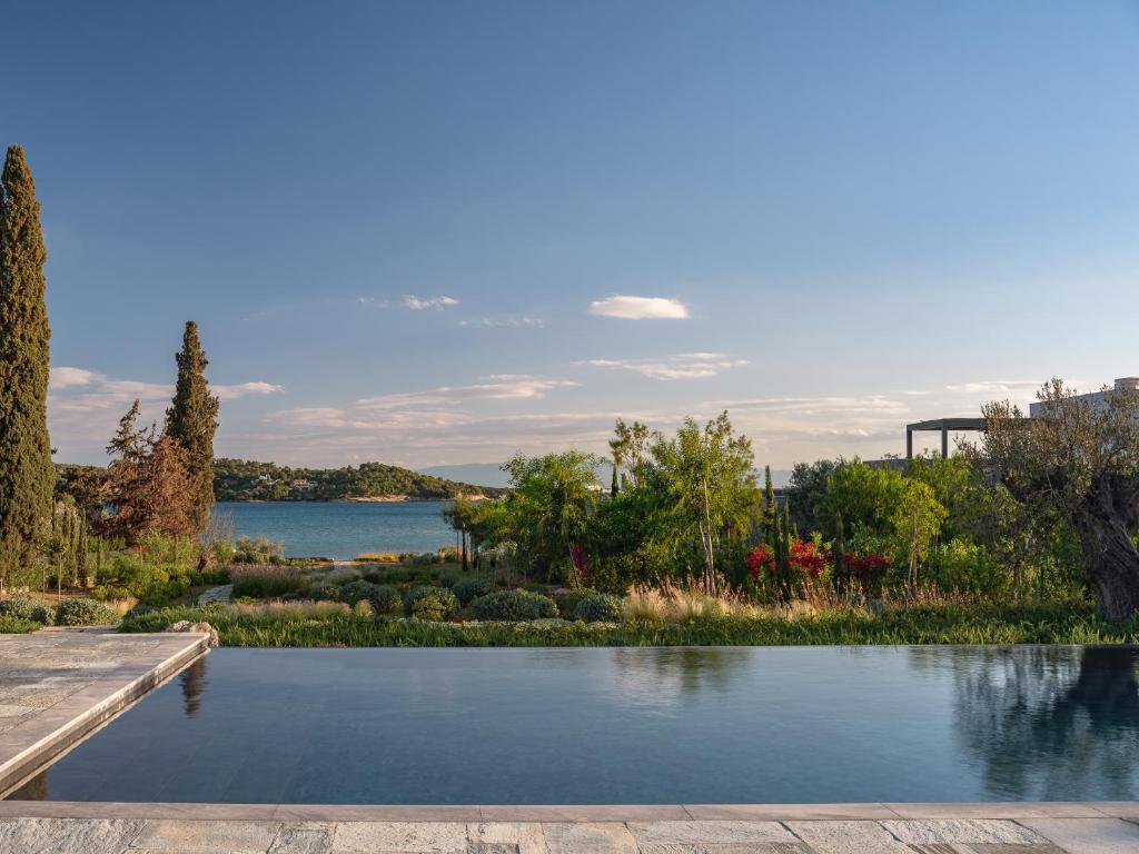 Infinity pool reflecting cypress, gardens and the bay at golden hour