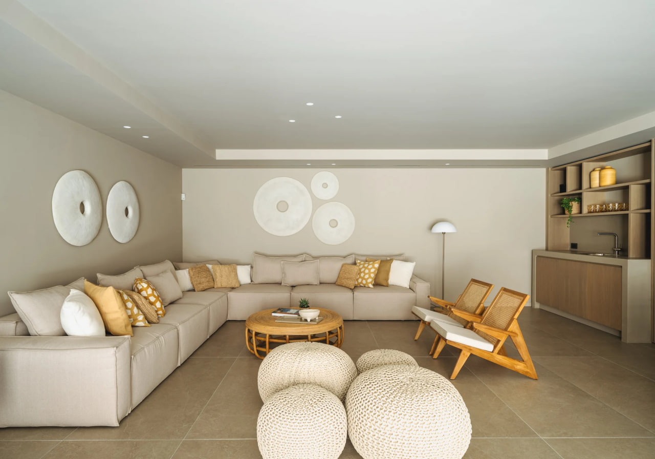 Lower-level lounge with corner sofa and woven poufs