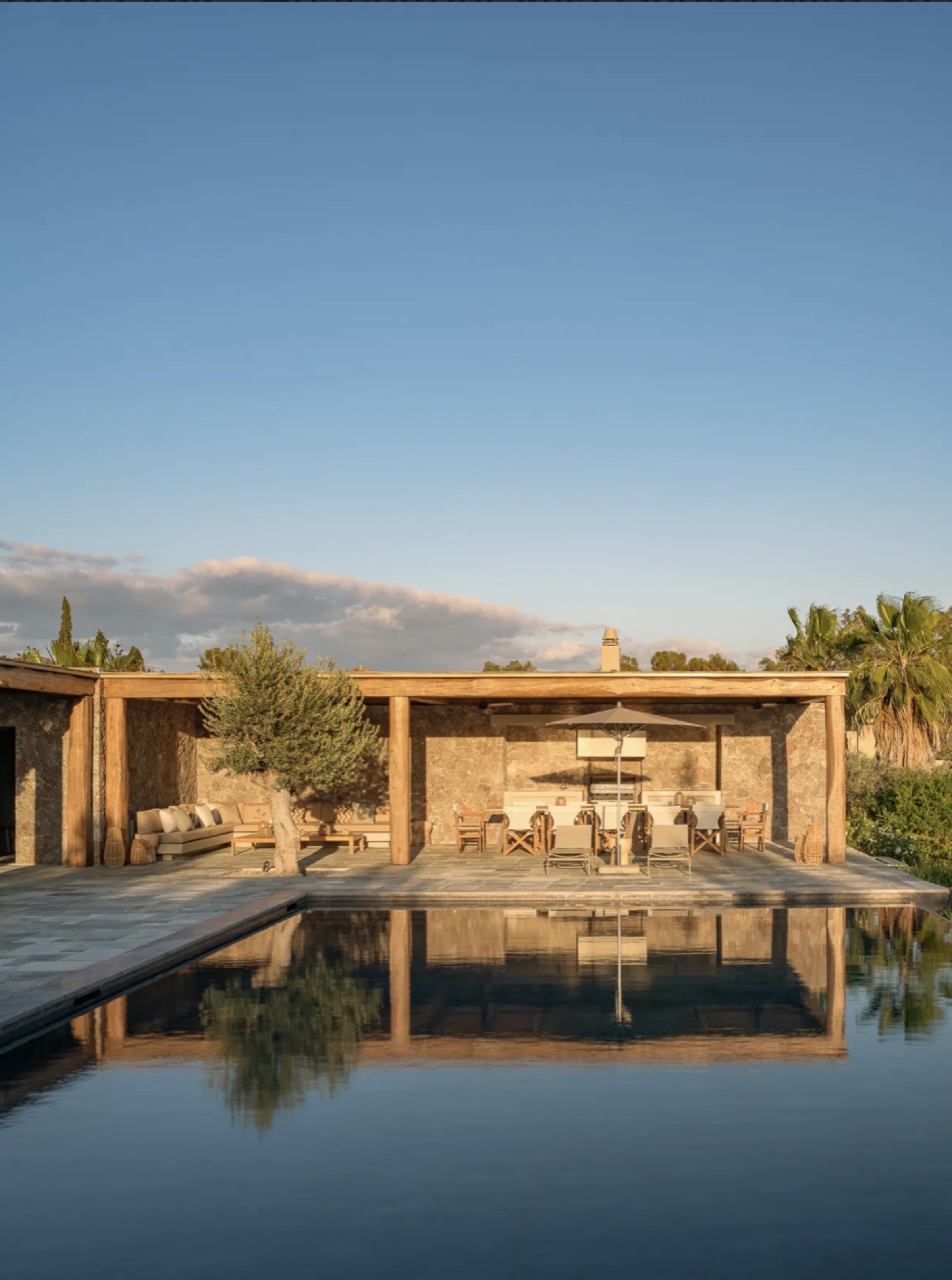 Pool reflecting the stone pavilion at dusk
