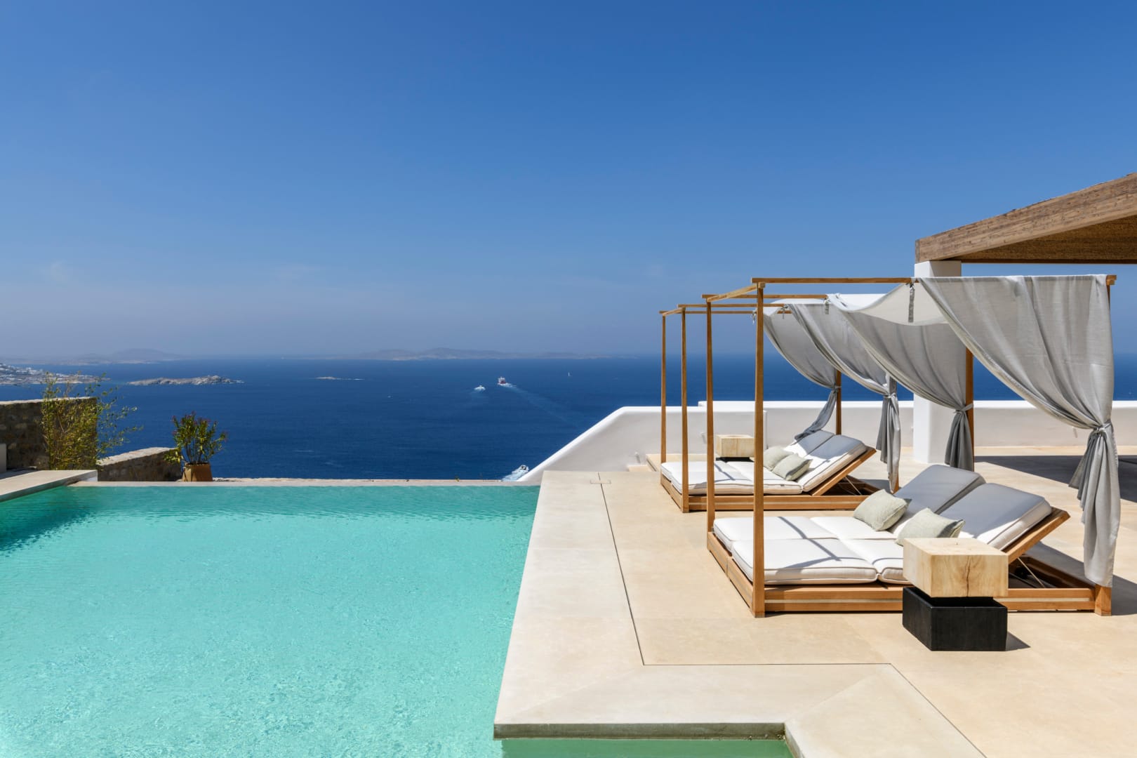 Infinity pool and canopied daybeds in full daylight