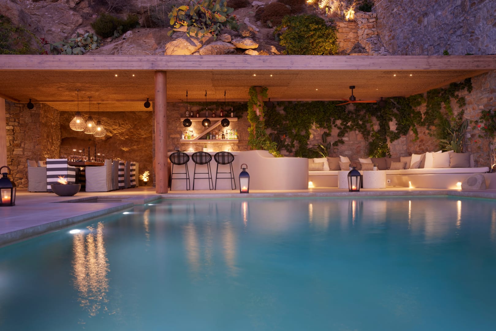 Lower-level pool and bar at night, set into the stone