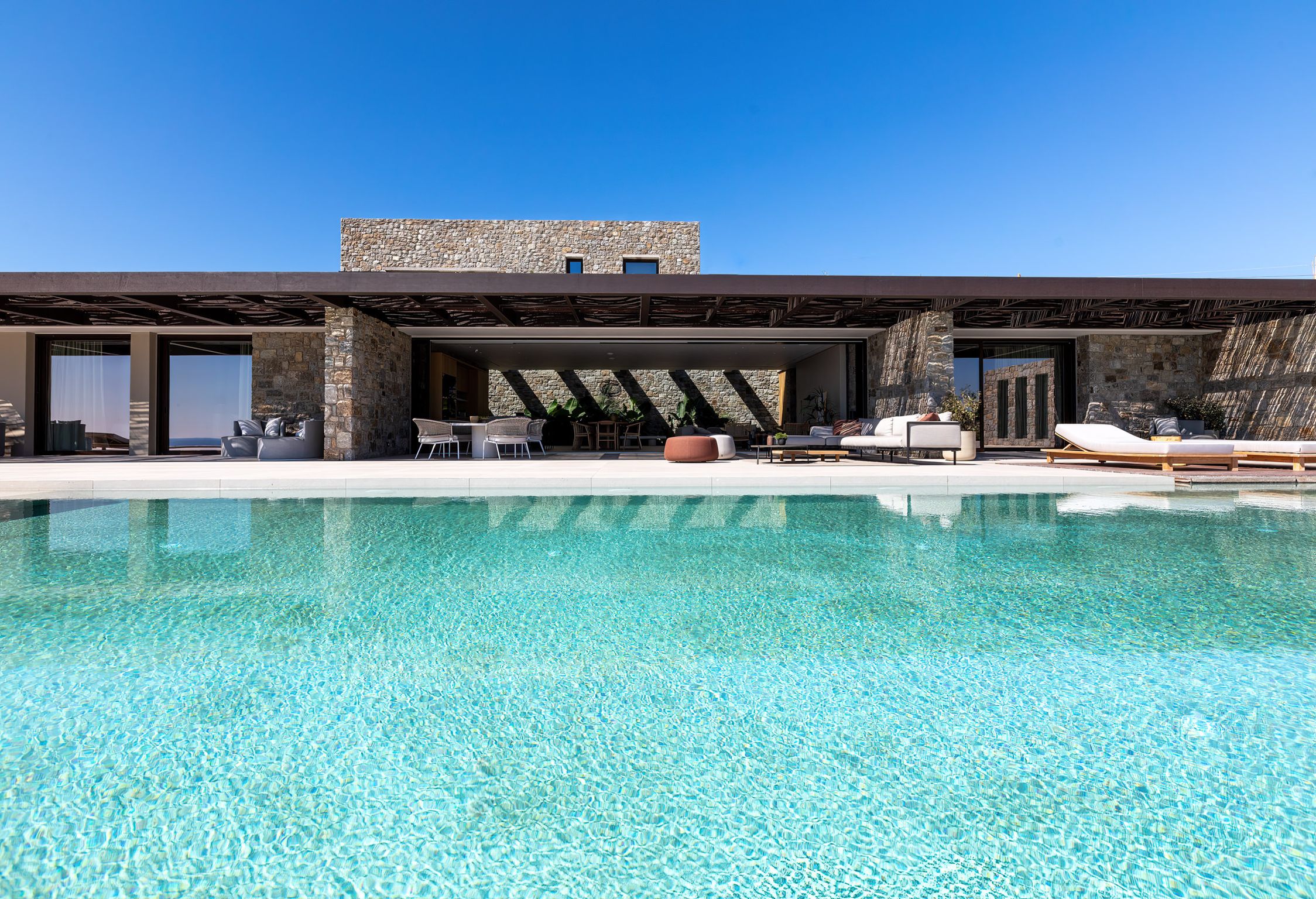 Villa facade opening onto the pool and the Aegean