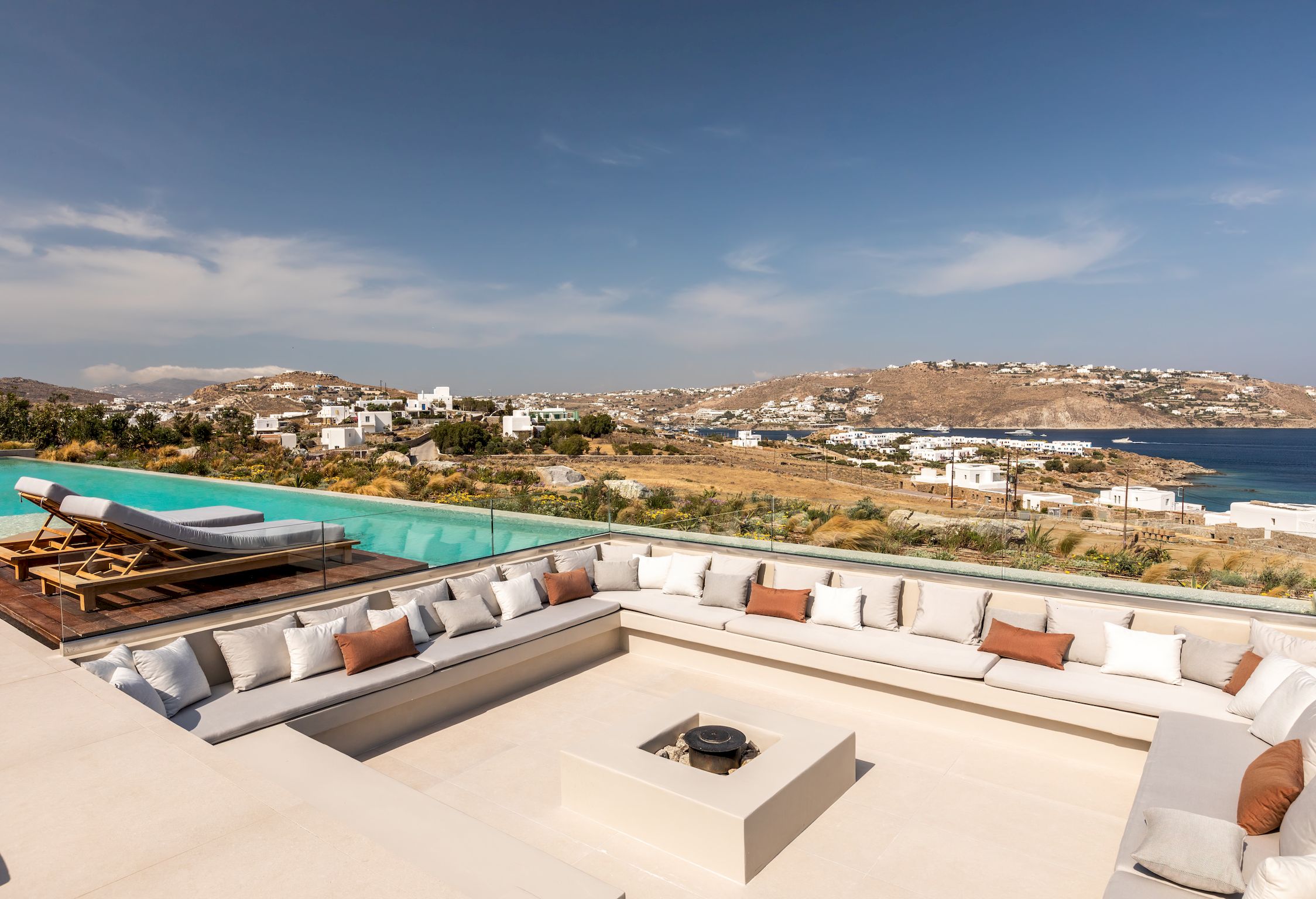 Rooftop lounge with open-air fire pit, Mykonos view beyond