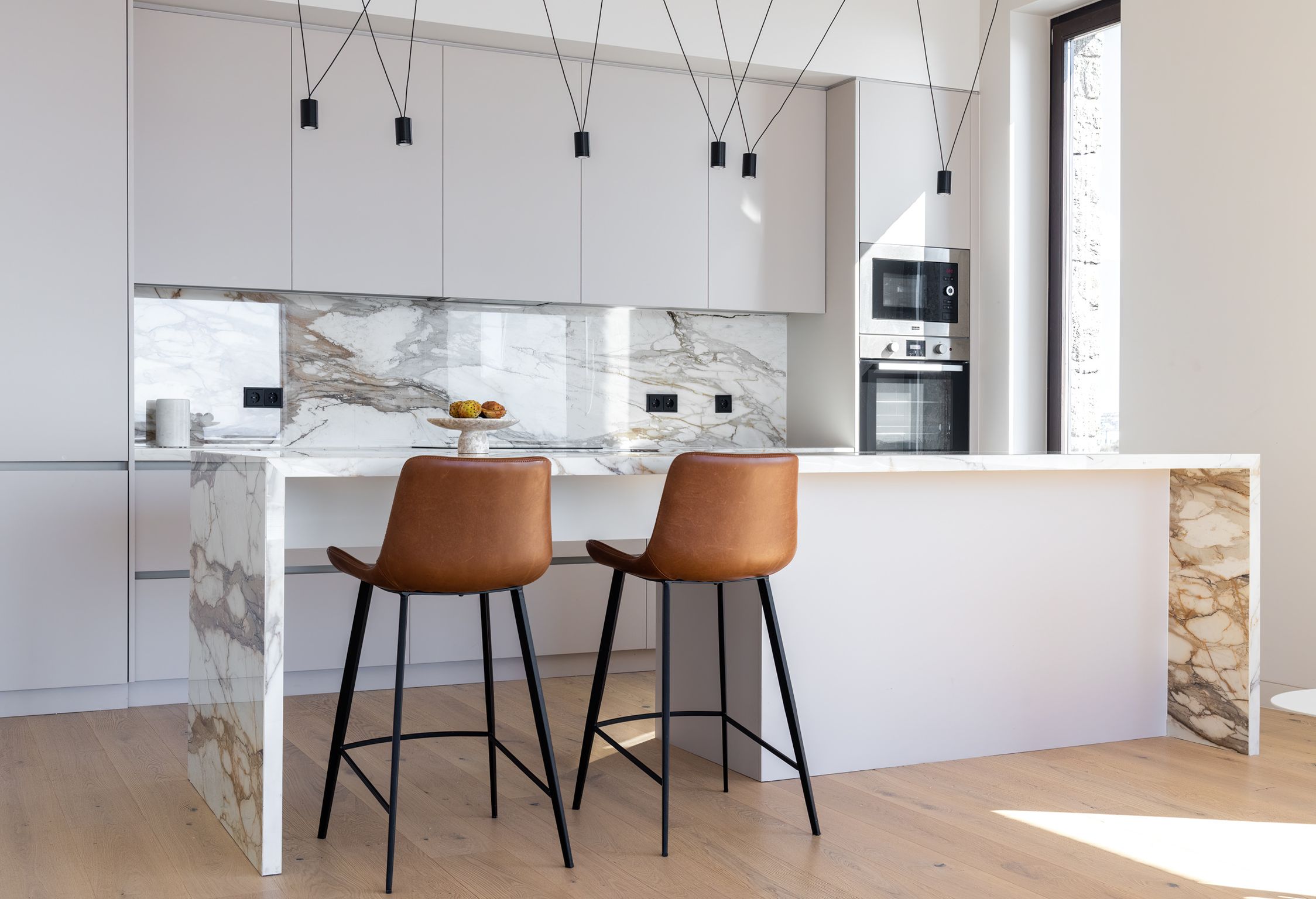 The kitchen, marble island and leather bar stools